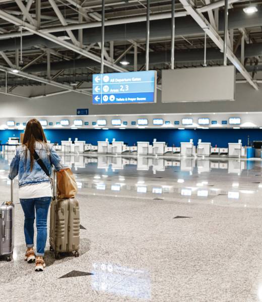 Woman walks along the airport with two suitcases